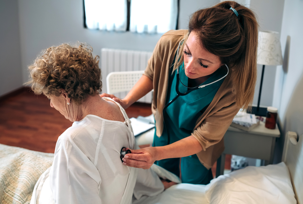 Healthcare professional examining elderly patient
