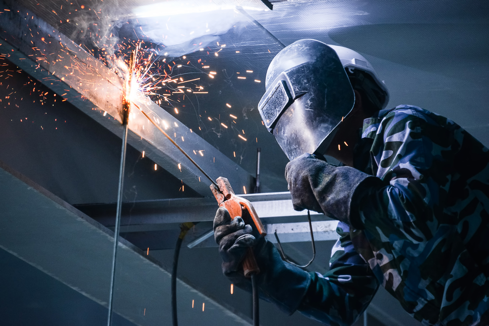 Welder working with sparks in industrial setting